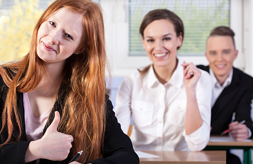 people in classroom giving thumbs up